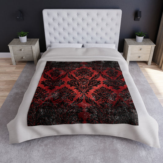Red and black damask floral throw blanket laid on bed over light bedding