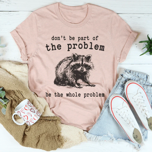 Dusty pink T-shirt with raccoon graphic and 'be the whole problem' slogan