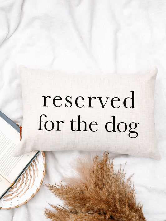 Cream fabric throw pillow with 'reserved for the dog' printed in black