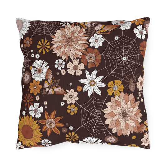 Brown outdoor throw pillow with spiderweb lines, white flowers, and orange floral accents