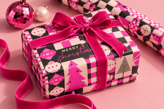 Christmas gift wrap paper on a wrapped present, pink plaid patchwork with trees