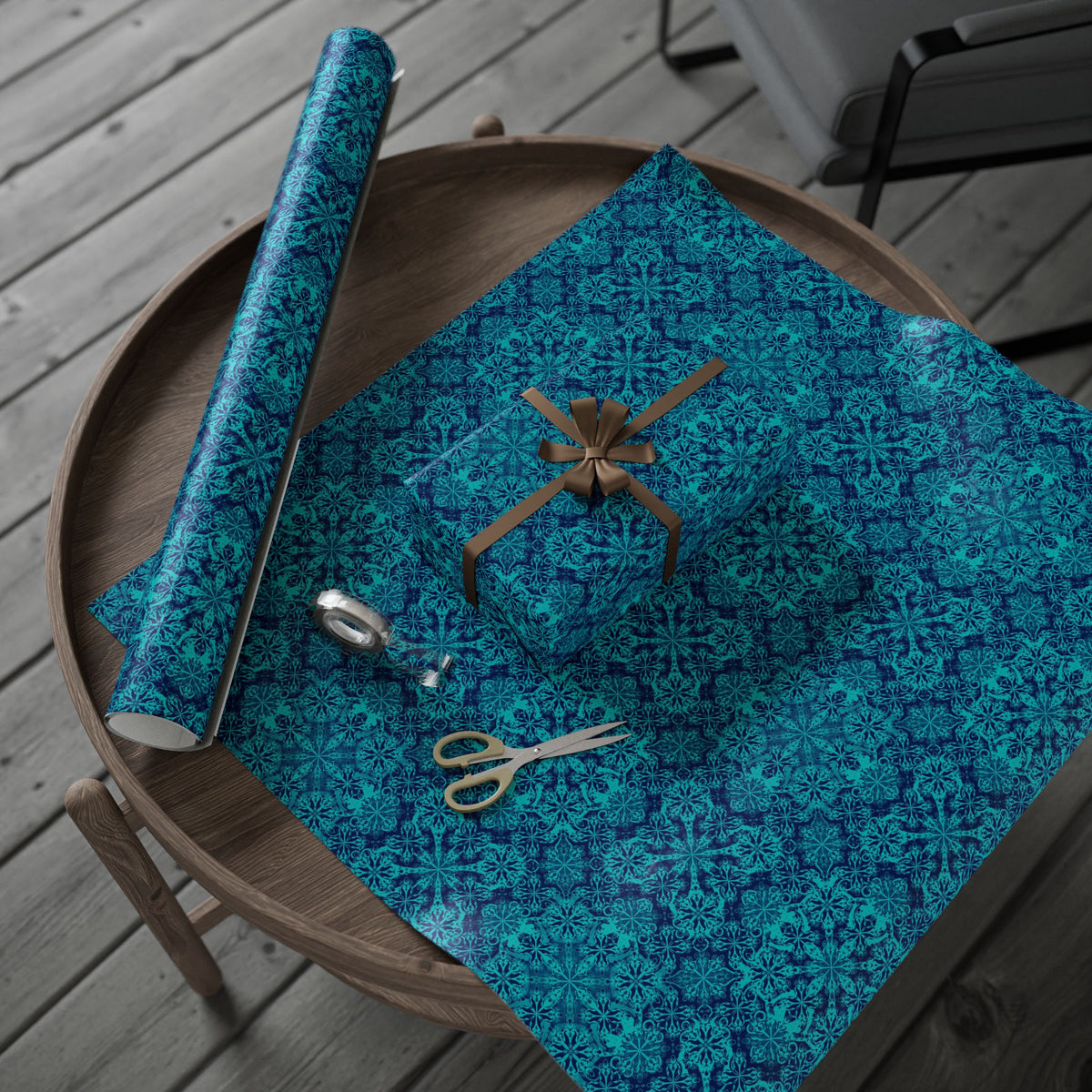 Teal wrapping paper roll and folded gift wrap sheet on wooden tray, Moroccan tile pattern