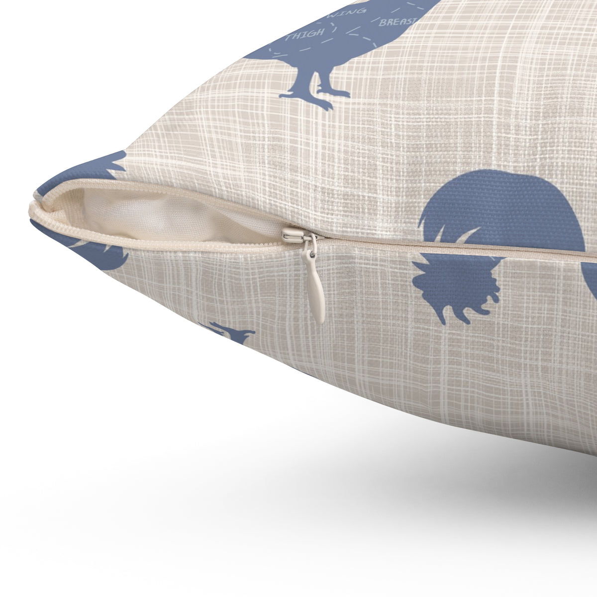 Rooster throw pillow in cream fabric with navy pattern; visible zipper closure and seam