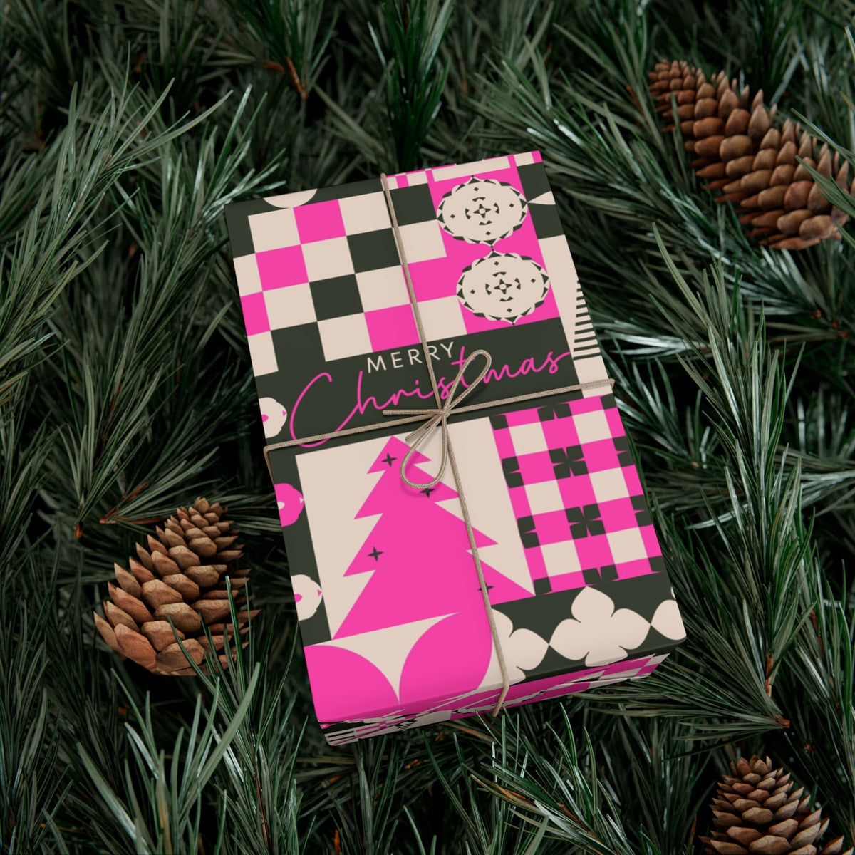 Pink and black patchwork Christmas wrapping paper with checkered blocks, ornaments, and text