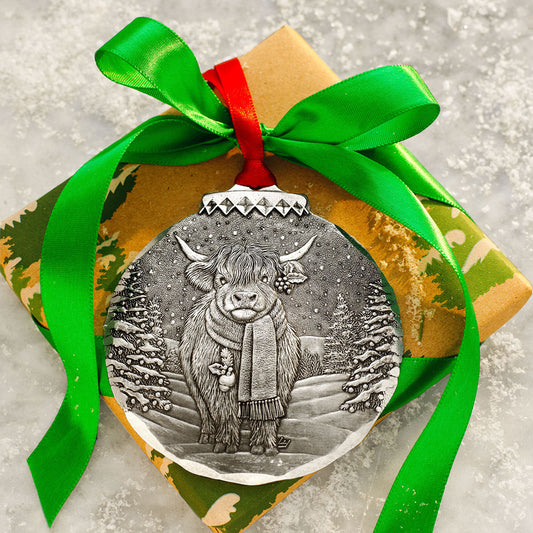 Grey cow Christmas ornament with hanging red ribbon and winter etched illustration