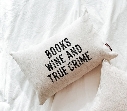 Off-white throw pillow with 'BOOKS WINE AND TRUE CRIME' text
